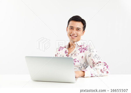 有使用計算機的被仿造的襯衣的一個年輕人 16655507