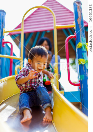 Parent and child playing on the slide 16661388