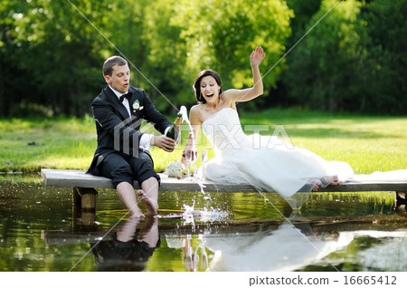 Bride and groom drinking champagne Bride and groom drinking champagne 16665412