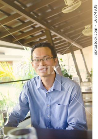 Asian businessman sitting in the restaurant Asian businessman sitting in the restaurant 16674939