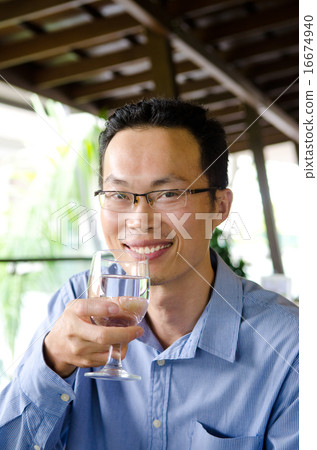 Asian man having a glass of drinks Asian man having a glass of drinks 16674940