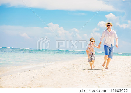 Father with son running barefoot on the sea surf line having great holidays time Father with son running barefoot on the sea surf line having great holidays time 16683072