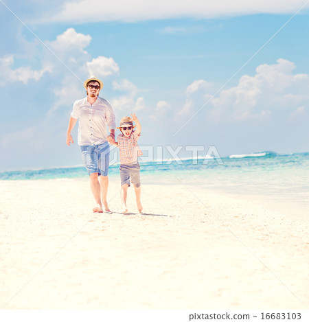 Father with son running barefoot on the sea surf line having great holidays time Father with son running barefoot on the sea surf line having great holidays time 16683103