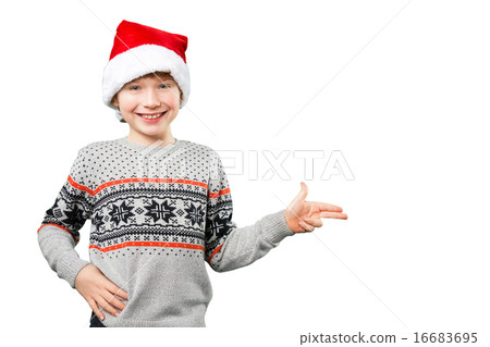 Portrait of a boy in christmas hat pointing at something with his fingers. Isolated 16683695