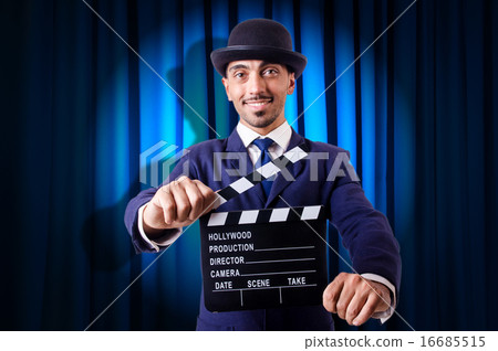 Man with movie clapper on curtain background 16685515