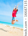 跳躍在海灘的一位小姐在沖繩島 16687135