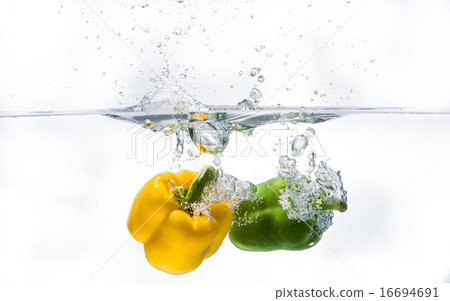 yellow and green pepperoni plunging into water 16694691