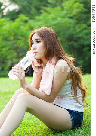 Woman sitting tired and drinking water after exercise. 16697981
