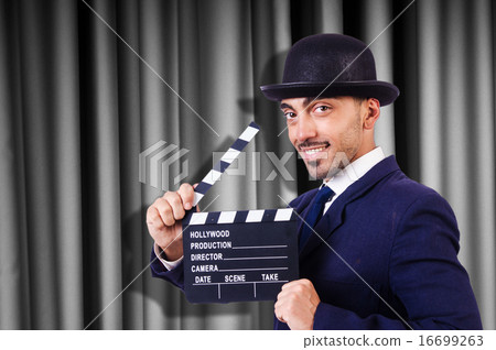 Man with movie clapper on curtain background Man with movie clapper on curtain background 16699263