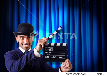 Man with movie clapper on curtain background Man with movie clapper on curtain background 16699982
