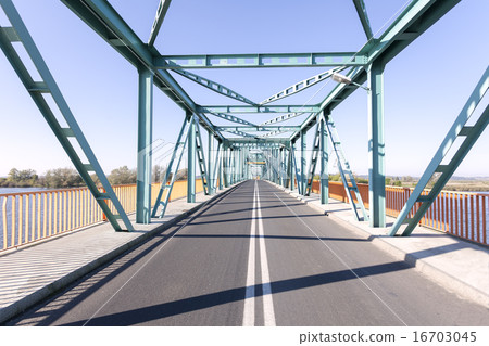 Photo of a long steel bridge over a river. 16703045