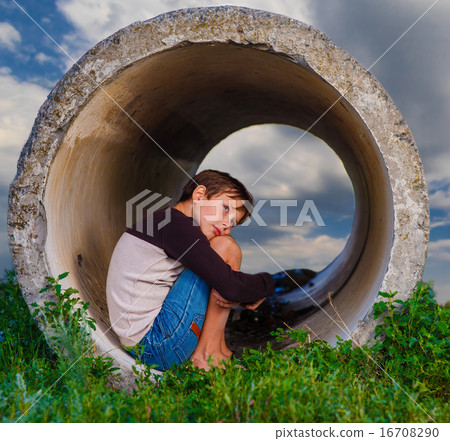 Homeless boy sad teenager sitting in the concrete pipe agoraphob 16708290