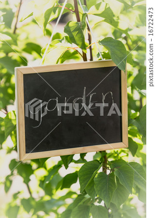 blackboard with text "Garden" hanging on tree 16722473