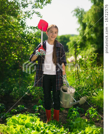 girl posing at garden with spade and watering can 16722576