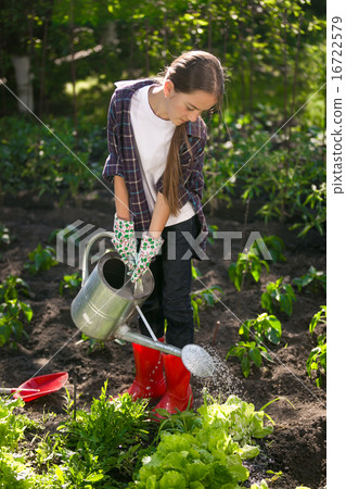 Cute girl watering garden with watering can Cute girl watering garden with watering can 16722579