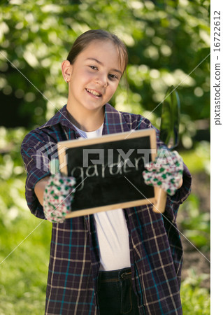 girl holding blackboard with text "Garden" 16722612
