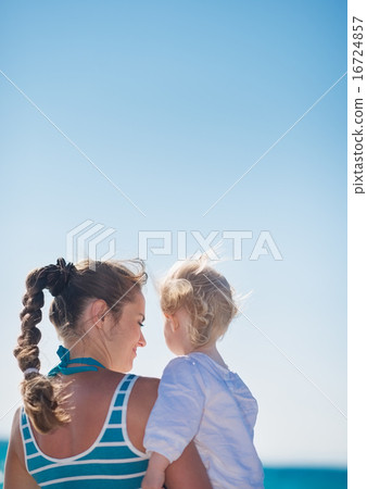 Portrait of mother and baby on beach. Rear view Portrait of mother and baby on beach. Rear view 16724857
