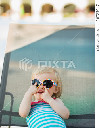 Baby in glasses laying on sun bed Baby in glasses laying on sun bed 16725047