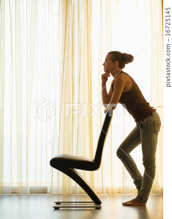 Silhouette of young woman leaning on modern chair Silhouette of young woman leaning on modern chair 16725145