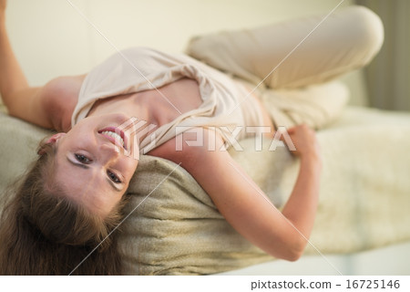 Smiling young woman laying on divan Smiling young woman laying on divan 16725146
