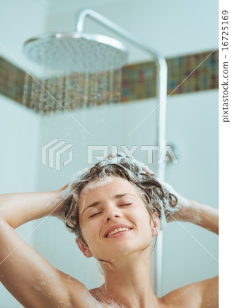 Young woman washing head with shampoo Young woman washing head with shampoo 16725169