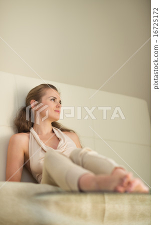 Thoughtful young woman sitting on couch Thoughtful young woman sitting on couch 16725172
