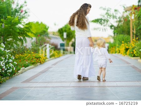 Mother and baby walking outdoors. Rear view Mother and baby walking outdoors. Rear view 16725219