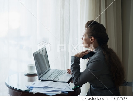 Thoughtful business woman working at hotel room 16725273