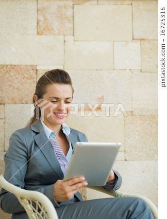 Happy business woman using tablet PC 16725318
