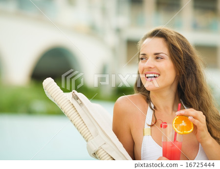 Happy young woman with cocktail looking on copy space Happy young woman with cocktail looking on copy space 16725444