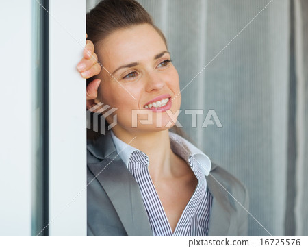 Dreamy business woman near window looking into distance 16725576