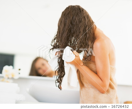 Young woman wiping hair with towel. rear view 16726432