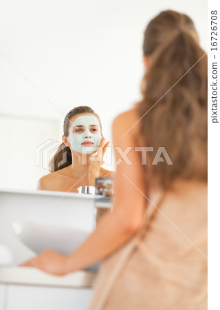 Young woman wearing facial cosmetic mask Young woman wearing facial cosmetic mask 16726708