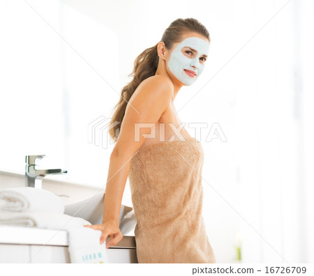 Portrait of happy young woman wearing facial cosmetic mask Portrait of happy young woman wearing facial cosmetic mask 16726709