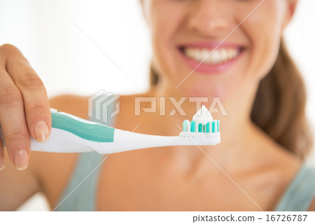 Closeup on young woman showing electric toothbrush 16726787