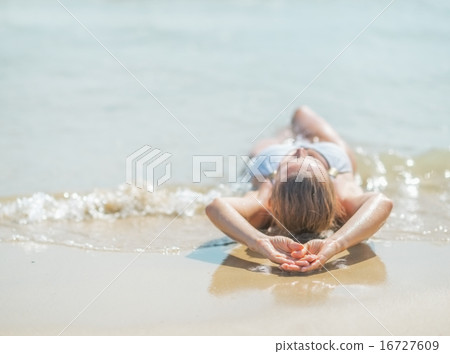Young woman in swimsuit laying on sea shore. rear view Young woman in swimsuit laying on sea shore. rear view 16727609