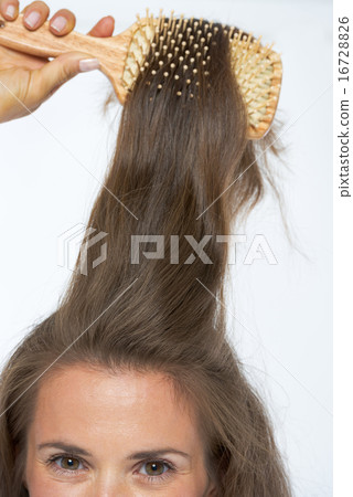 Closeup on young woman combing hair 16728826