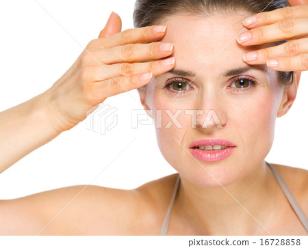 Beauty portrait of concerned young woman checking facial skin Beauty portrait of concerned young woman checking facial skin 16728858