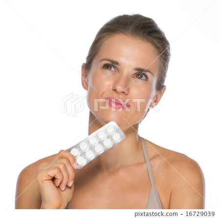 Portrait of thoughtful young woman with blistering package of pi Portrait of thoughtful young woman with blistering package of pi 16729039