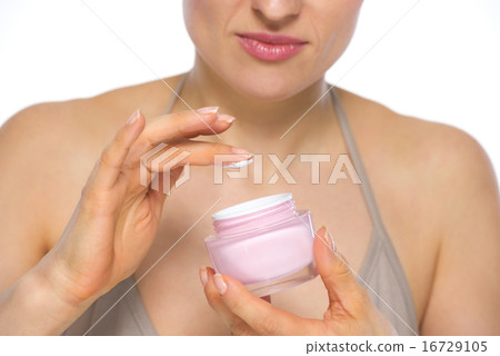 Closeup on young woman applying creme Closeup on young woman applying creme 16729105