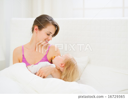 Happy young mother holding sleeping baby Happy young mother holding sleeping baby 16729365