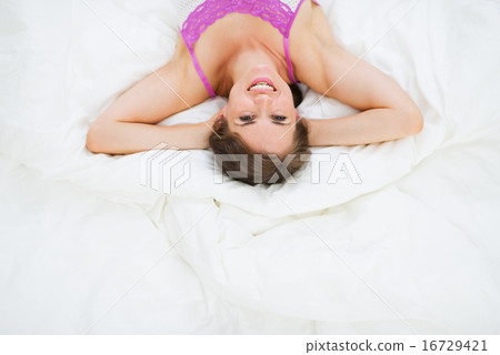 Portrait of happy girl laying on bed Portrait of happy girl laying on bed 16729421