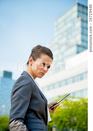 Portrait of serious business woman with tablet pc in office dist Portrait of serious business woman with tablet pc in office dist 16729486