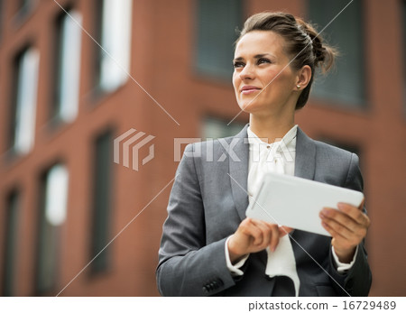 Business woman with tablet pc in front of office building Business woman with tablet pc in front of office building 16729489