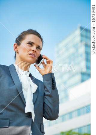 Business woman talking mobile phone in office district 16729491
