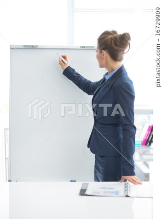 Business woman writing on flipchart 16729909