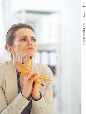 Portrait of thoughtful business woman holding pencils Portrait of thoughtful business woman holding pencils 16729910