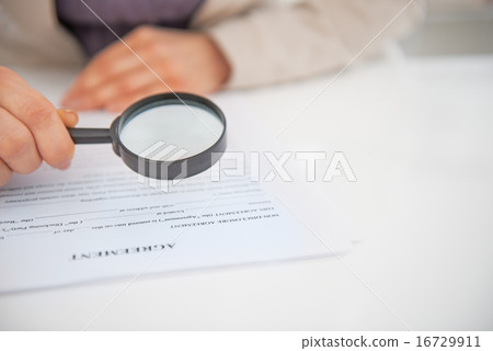 Closeup on business woman exploring document with magnifying len Closeup on business woman exploring document with magnifying len 16729911