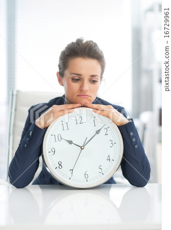 Frustrated business woman with clock Frustrated business woman with clock 16729961
