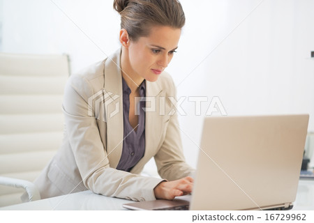 Business woman working on laptop in office Business woman working on laptop in office 16729962